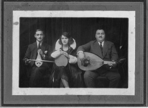 'Greek Blues' singer Roza Eskenazi holding tambourine with two musicians either side