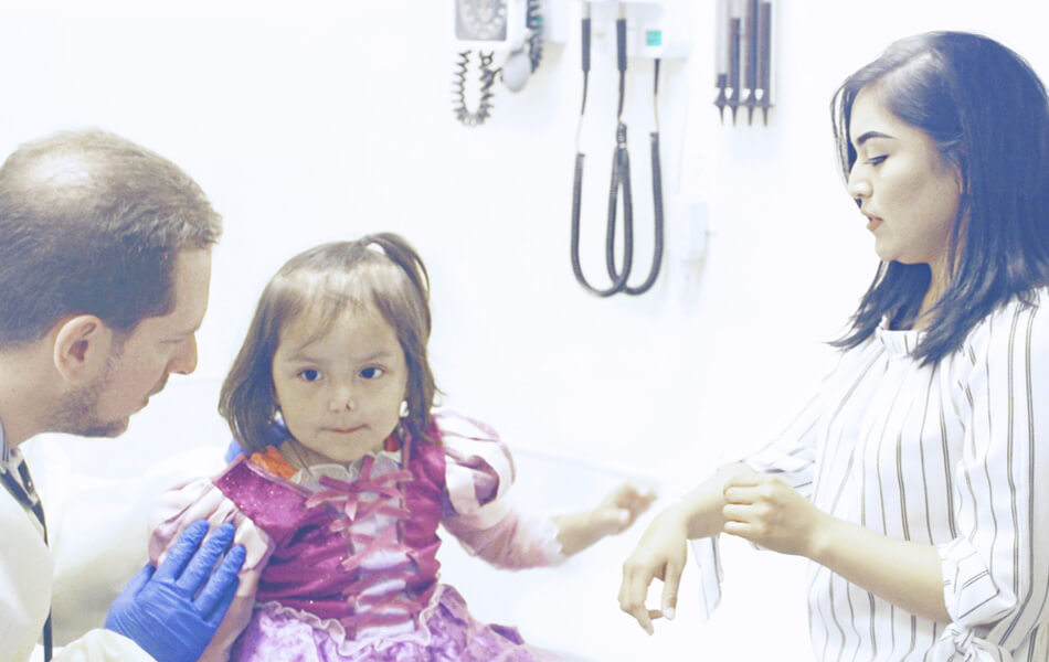 A young child in hospital being seen by a doctor.