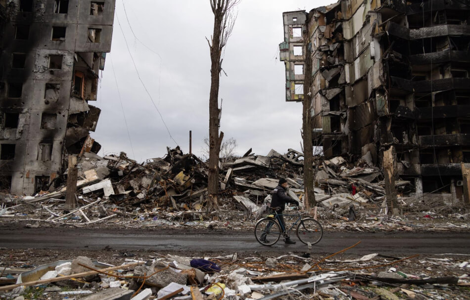 Man walking his bicycle amidst the rubble in Ukraine following Russia’s invasion