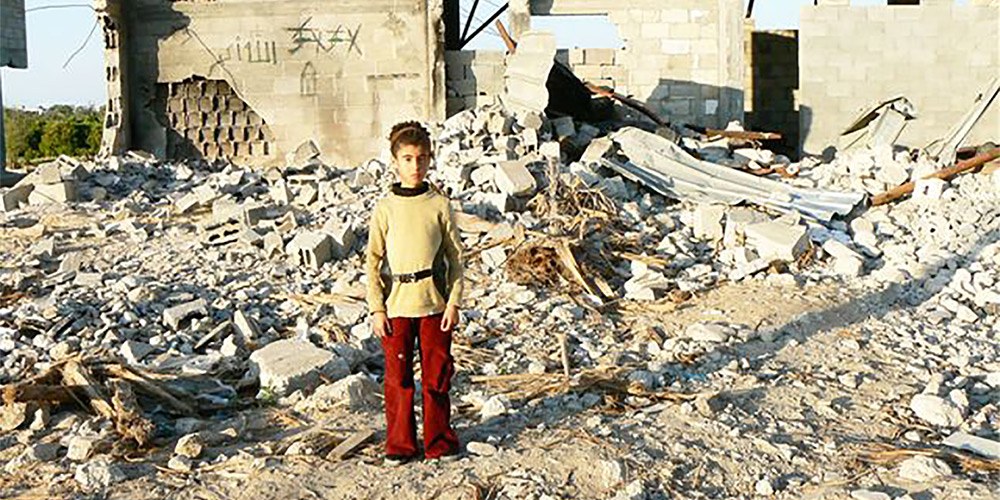 Young child standing among rubble