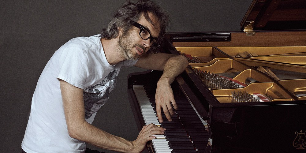Classical pianist James Rhodes sitting at a grand piano