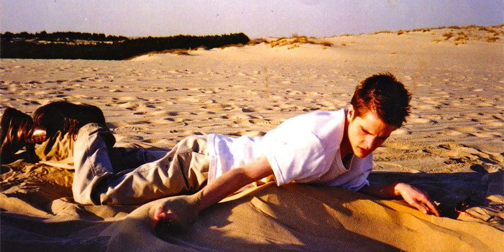 Matt Shepard lying on a beach