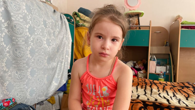 A picture of a small Ukrainian girl called Kira in the basement of a house which has become a bunker